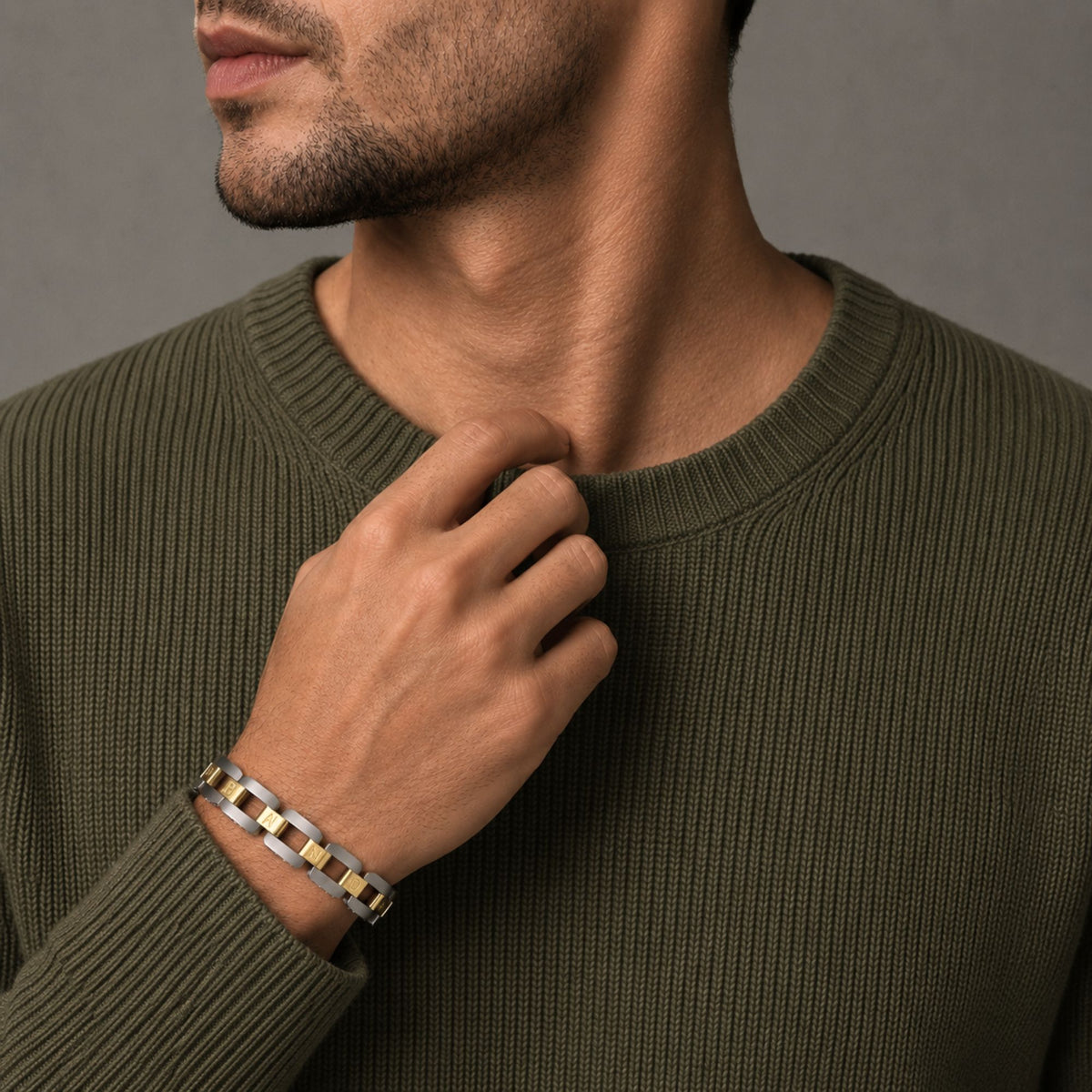 Man in an olive knit wearing the Bandor Essence Link Bracelet in platinum and 18k gold