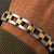 Close-up of the Bandor Essence Link Bracelet on the wrist, BANDOR spelled across 18k gold links