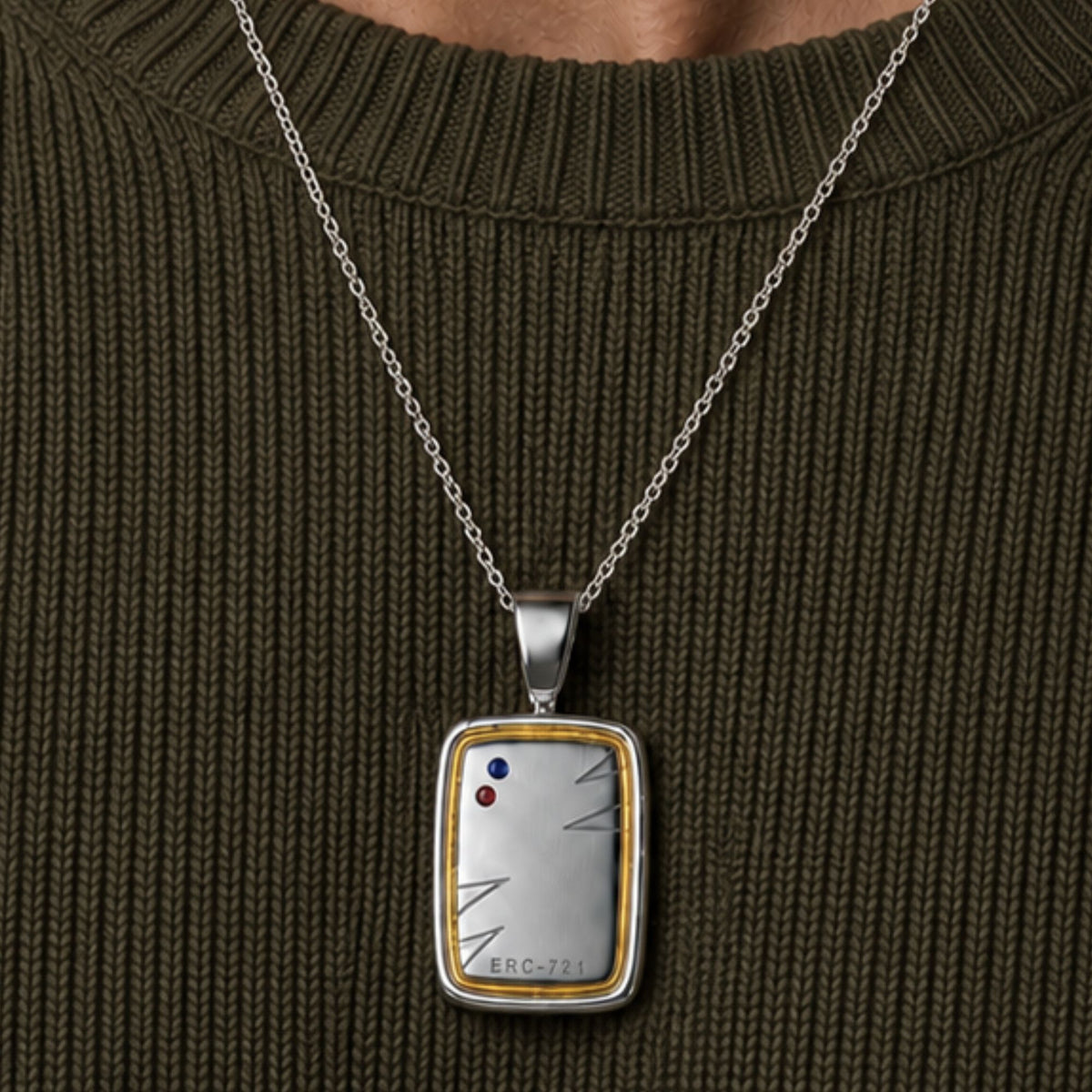 Close-up of the Bandor Essence Pendant on a navy knit: platinum plate framed in 18k gold, ERC-721 engraving