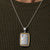 Close-up of the Bandor Essence Pendant on a navy knit: platinum plate framed in 18k gold, ERC-721 engraving