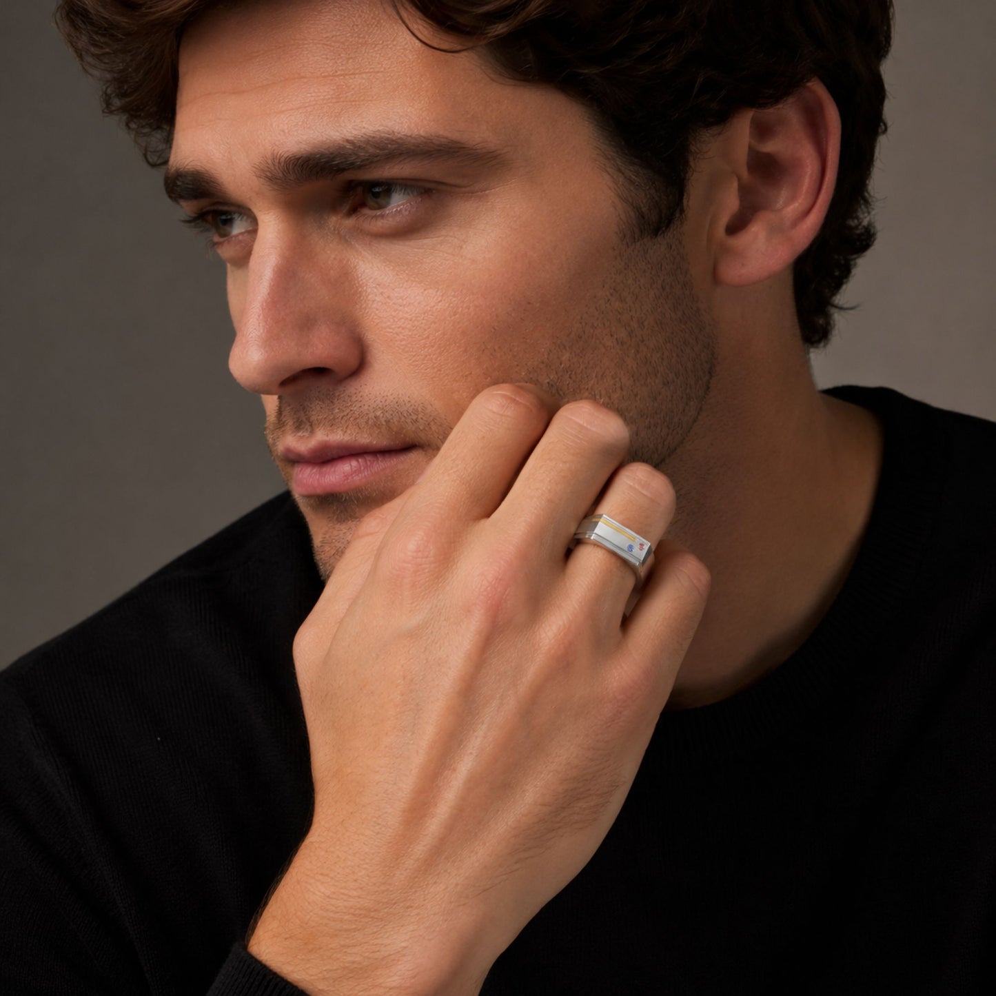 Man wearing the Bandor Essence Ring in platinum and 18k gold, hand resting against his jaw