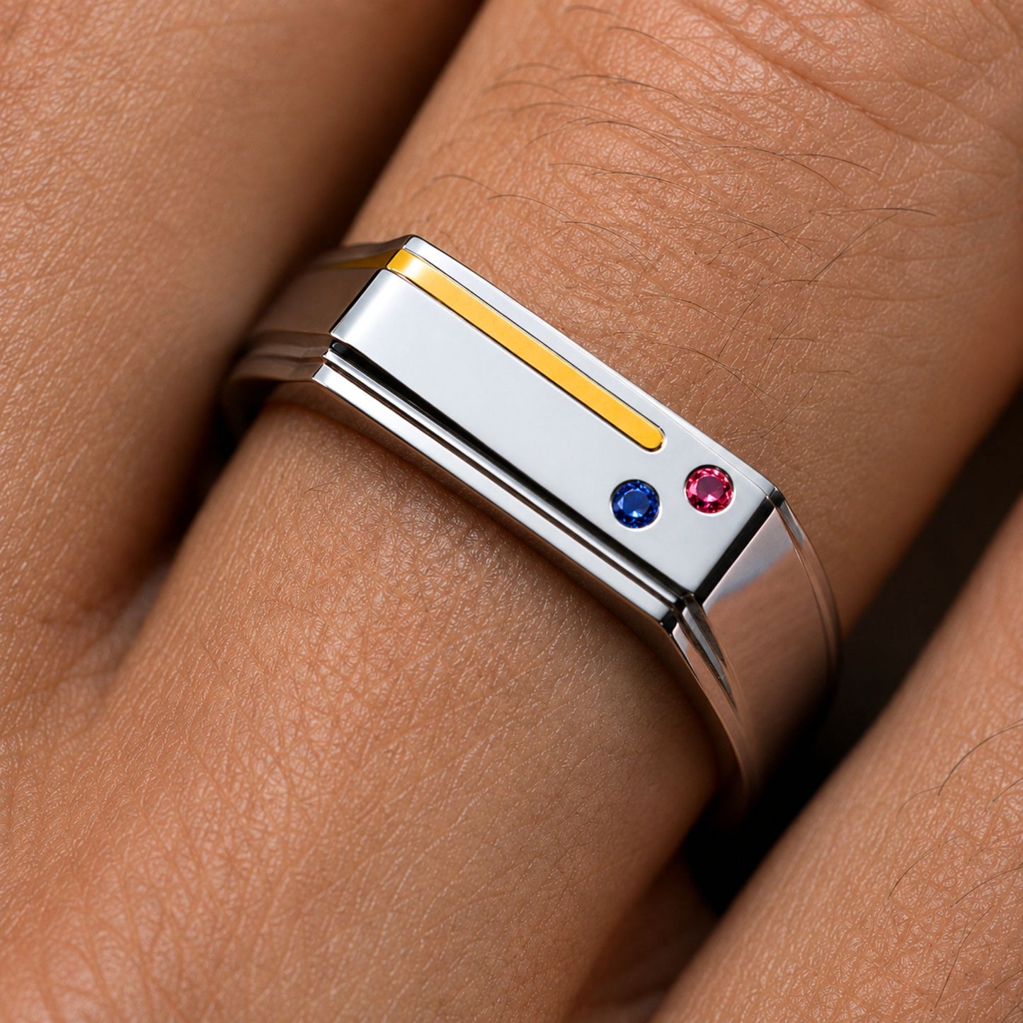 Close-up of the Bandor Essence Ring on the finger: 18k gold inlay with flush-set ruby and sapphire