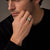 Man in a dark knit wearing the Bandor Signet Ring, a luxury men's signet ring in solid platinum, the bolt seal squared in its octagonal bezel.