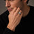 Man in a dark knit wearing the Bandor Signet Ring in platinum, the bolt seal squared in its octagonal bezel