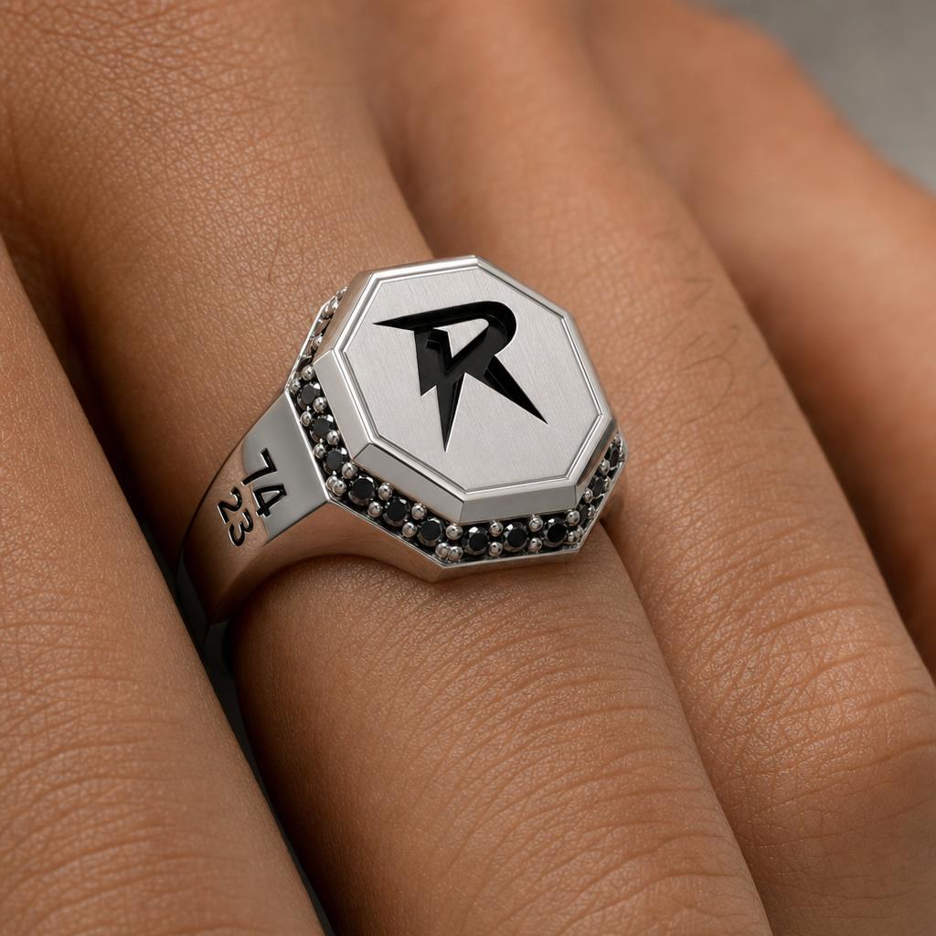 Close-up of the Bandor Signet Ring on the finger: octagonal platinum face, bolt seal, black diamond halo and 7423 engraving