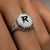 Close-up of the Bandor Signet Ring on the finger: octagonal platinum face, bolt seal, black diamond halo and 7423 engraving