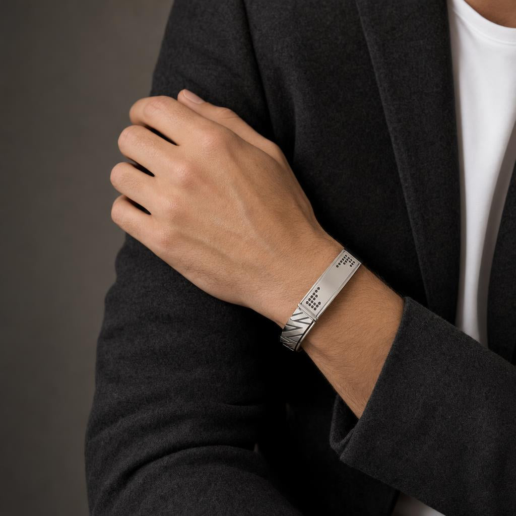 Man in a charcoal blazer wearing the Bandor Vanguard Cuff in platinum on his wrist, black diamond plaque visible