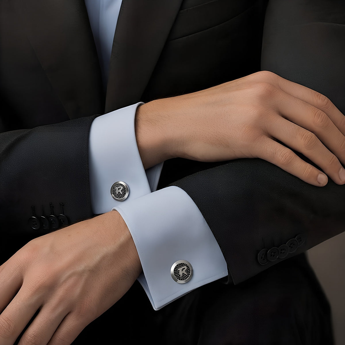 Man in a charcoal blazer and pale blue french-cuff shirt wearing the Bandor Vault Cufflinks, luxury men's cufflinks in solid platinum with natural black diamond pave.