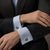 Man in a charcoal blazer and pale blue french-cuff shirt wearing the Bandor Vault Cufflinks, luxury men's cufflinks in solid platinum with natural black diamond pave.